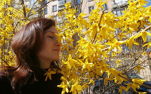 Олга вдишва ароматите на жълти цветя