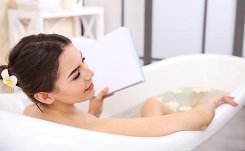 Момиче чете, докато се къпете