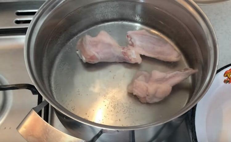Потопете пилешките крилца във вода, оставете да се готви.