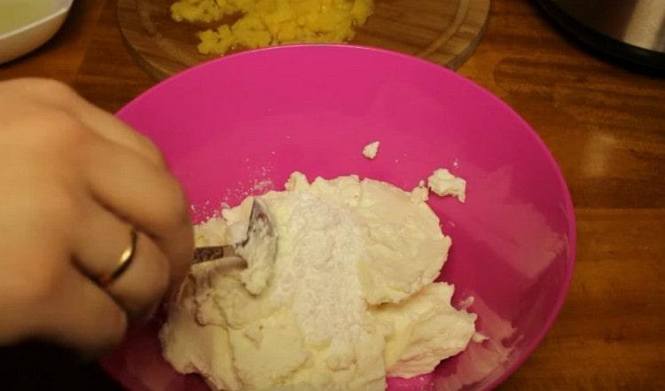 Upang ihanda ang cream, ihalo ang curd cheese na may pulbos na asukal.