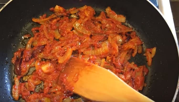 Добавете доматеното пюре към лука и разбъркайте пърженето.