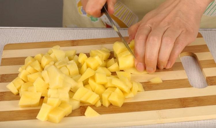 Обелете и нарежете картофите на парчета.