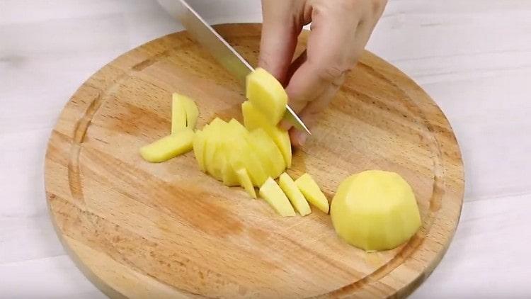 Обелете и нарежете картофите на парчета.