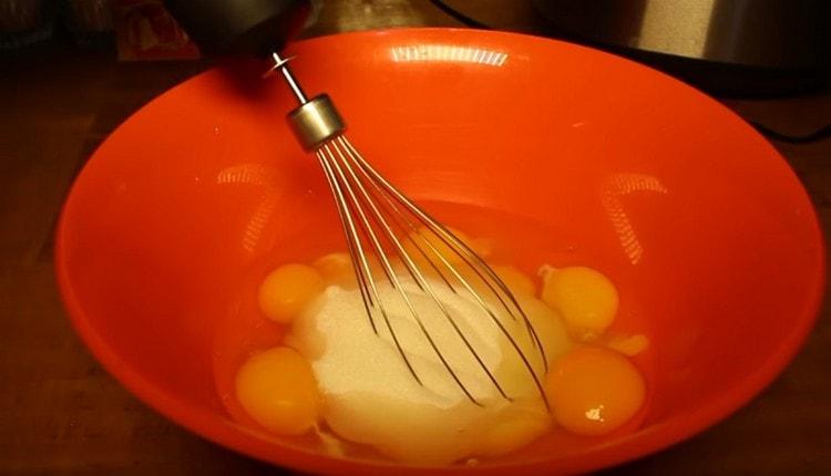 Разбийте яйцата със захарта.