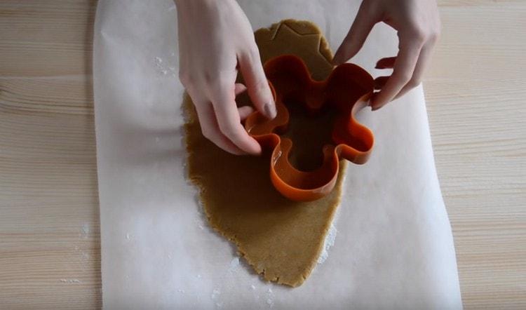 Нарежете бисквитките от тестото с помощта на резачки за бисквитки.