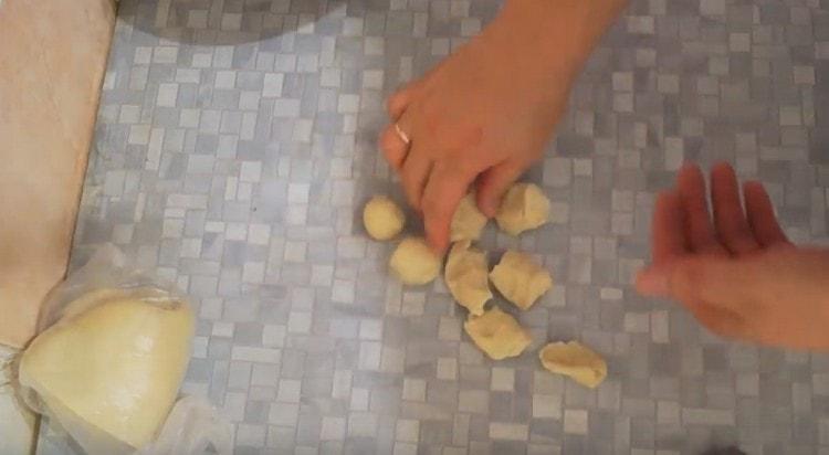 Нарязваме наденицата тесто на парчета и ги навиваме на топки.