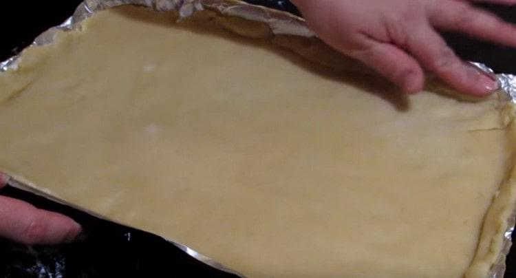 Поставяме разточеното тесто върху лист за печене, покрит с фолио или пергамент.