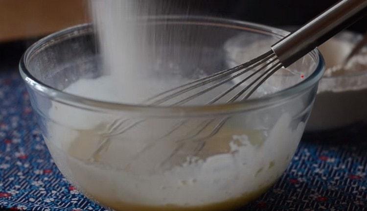 Пресейте брашното до течните компоненти и омесете тестото, което не полепва по ръцете.