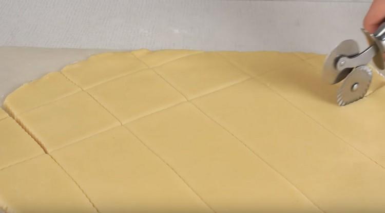 Нарежете разточеното тесто с нож за пица на малки квадратчета.