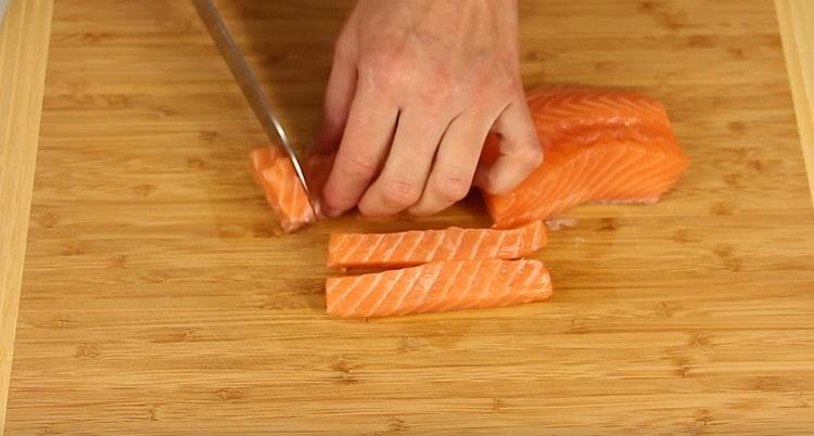 Нарежете филето от червена риба без кости на малки парченца.