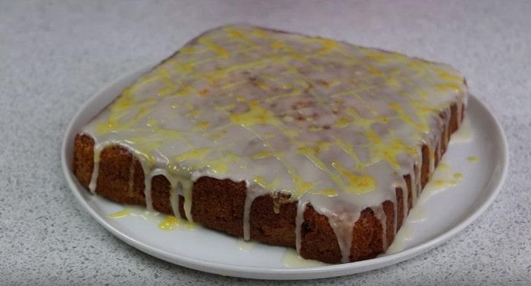 Залейте тортата с моркови с бяла и жълта глазура.