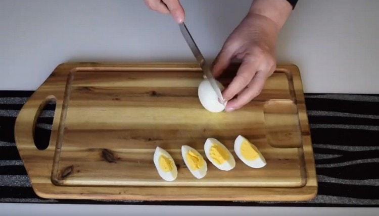 Нарязваме сварените яйца на четвъртинки.