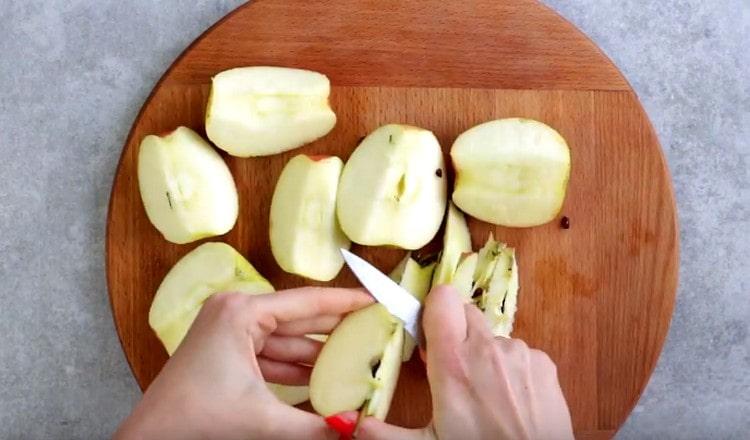 Нарежете ябълките на четвъртинки, отстранете семената.