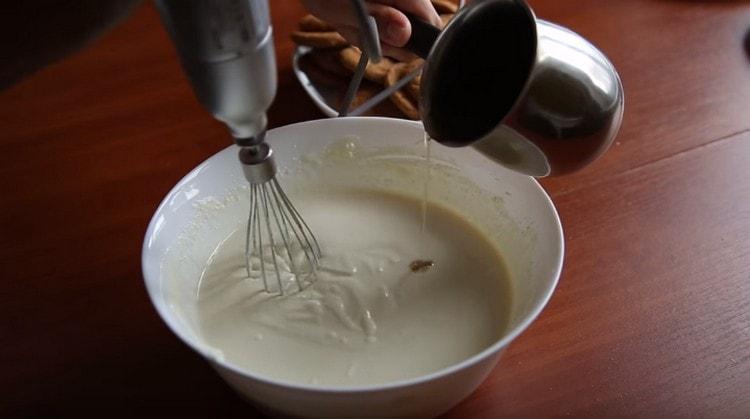 Ipasok ang gelatin sa isang manipis na stream sa masa ng curd.