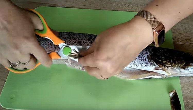 Изрязваме перките от рибата с кухненски ножици.