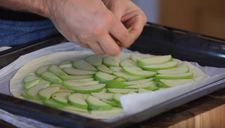 Поставяме ябълки отгоре на тестото, отстъпвайки на няколко сантиметра от ръба.