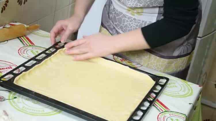 За да направите пай с риба и картофи, сложете тестото върху лист за печене