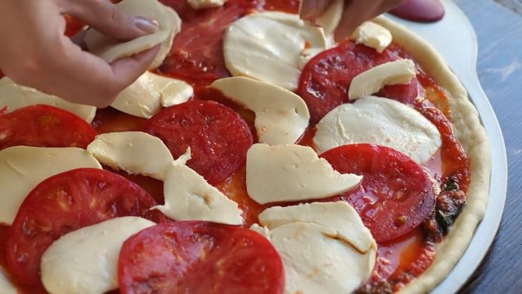 За да направите пица с маргарита, сложете пълнежа върху тестото