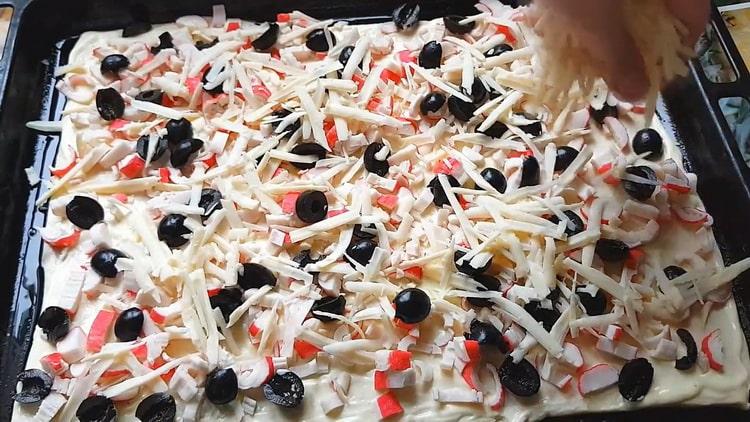 За да направите пица с ракови пръчици, сложете пълнежа върху тестото
