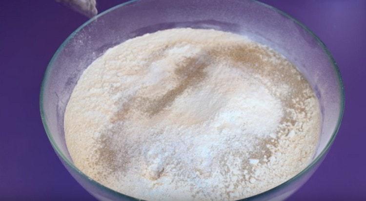 Към брашното добавете захарта, солта и сушената мая.