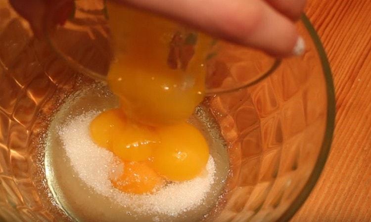 Разбиваме едно яйце в купа, добавяме още три жълтъка и ванилова захар.