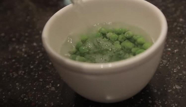 Nalijte vařenou vodu na zmrzlý zelený hrášek.