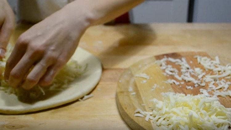 В центъра на тестото разпределяме почти цялото сирене.