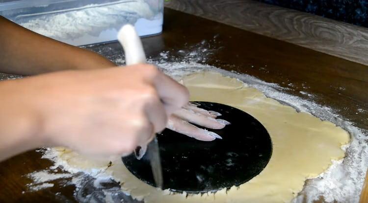 Използвайки дъното на съда за печене като шаблон, изрежете кръг от тестото.
