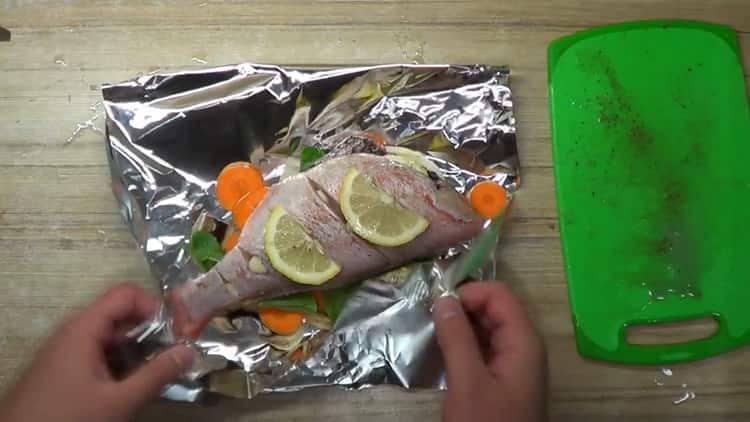 за готвене на костур във фурната във фолио, сложете рибата с лимон върху фолиото