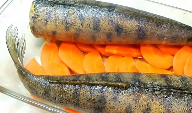 За да готвите пълнен зандър, сложете рибата върху морков