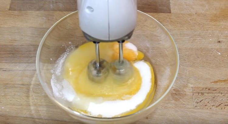 Разбийте яйцата със захарта отделно.