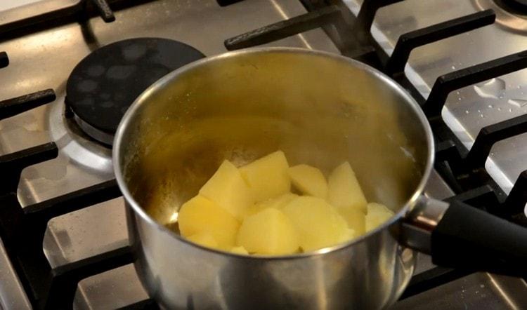 Изцеждаме водата от сварените картофи, докато се сварят.