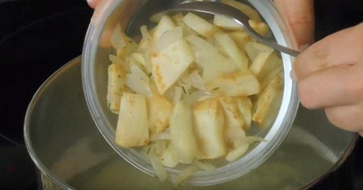 В картофите сложете пържената целина с лук и чесън в тигана.