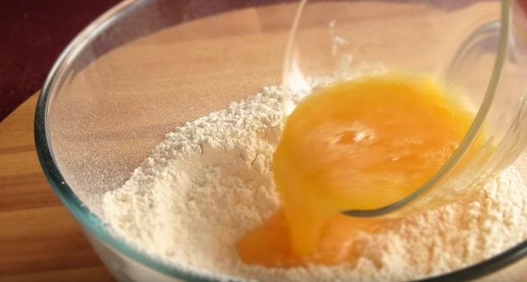 Изсипете яйцата в брашното.