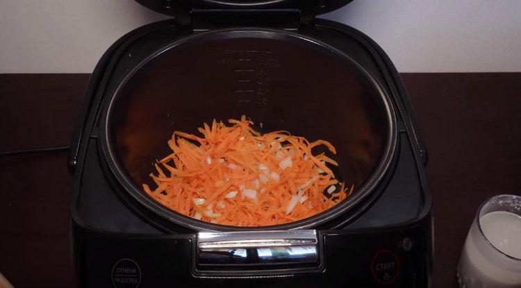 Разстелете половината лук и моркови в купата за мултикукър.