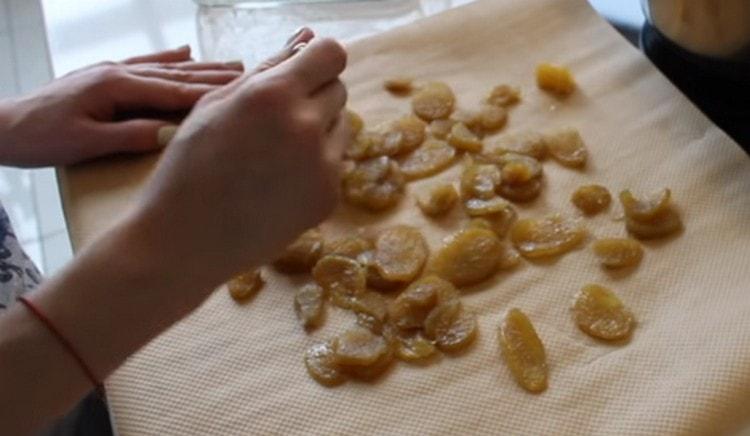 Поставете парченца джинджифил върху пергамент, за да изсъхне, като ги поръсите със захар.