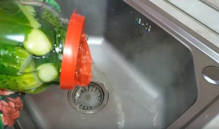 Изцеждаме напълно водата от консервите с краставици.