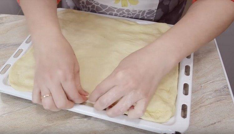 разточете второто парче тесто, покрийте ги с пълнежа и прищипете краищата.