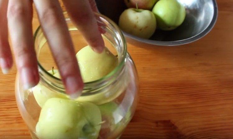 Напълнете стерилизирани буркани до върха с старателно измити ябълки.