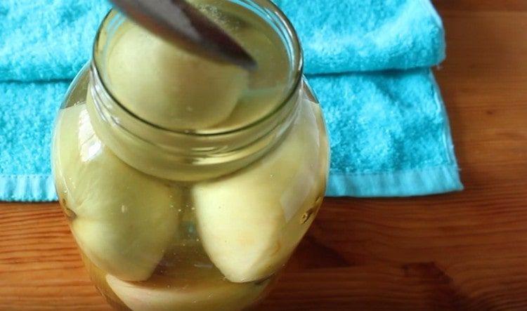 Изсипете ябълки в буркан с горещ сироп, добавете лимонена киселина.
