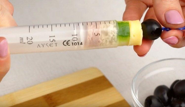 сложете маслина върху шишче и го нанижете в съставките в спринцовка.