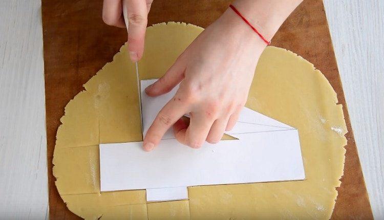 С помощта на лист хартия изрязваме фигури от тестото.