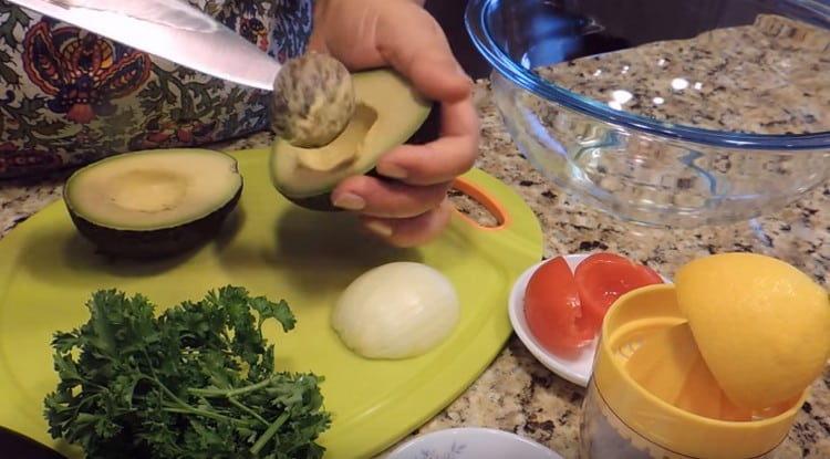 Нарежете авокадото наполовина и отстранете костилката.