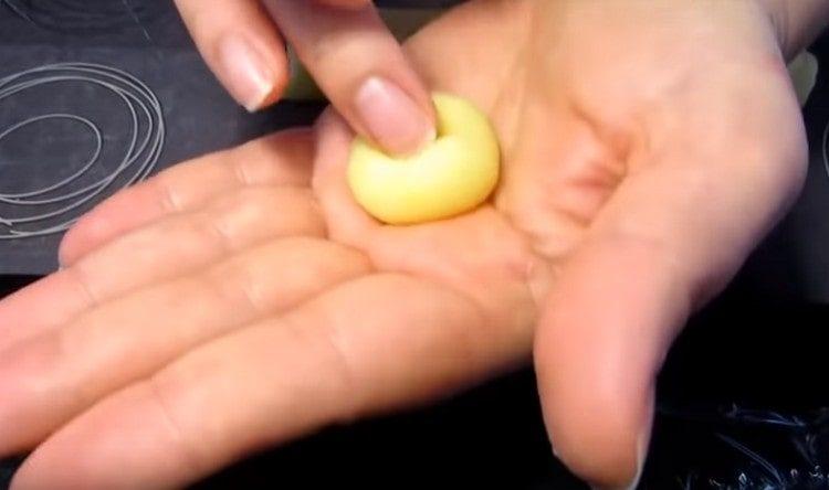 навиваме всяко парче картофена маса в топка и правим вдлъбнатина в нея с пръст.