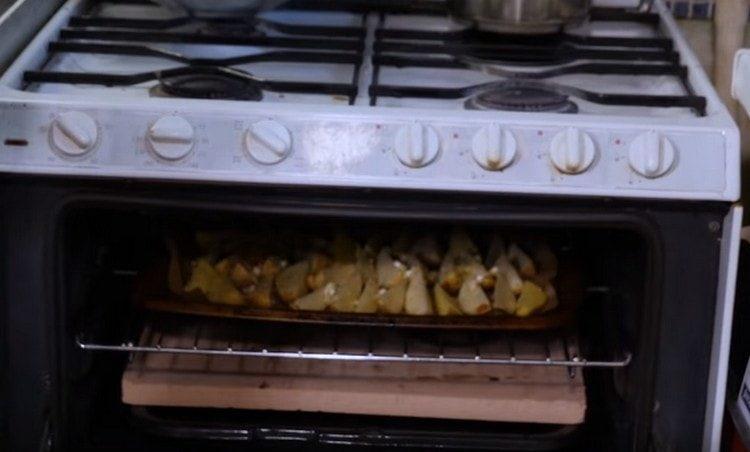 Сложете тавата за печене с картофи във фурната.