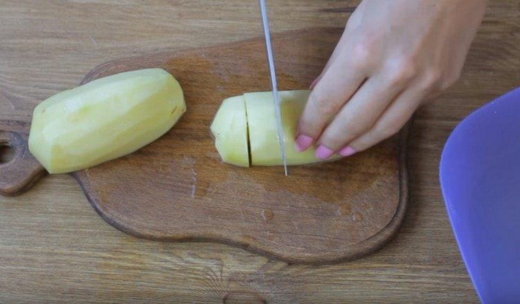 Обелете картофите и ги нарежете на парчета.