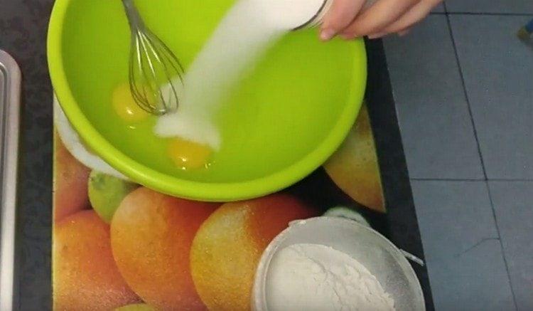 Разбийте яйцата със захарта отделно.