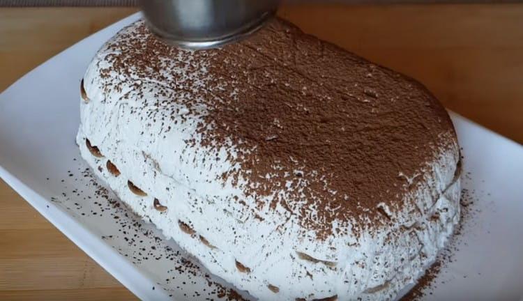 Завъртете готовата торта върху чиния и поръсете какао.
